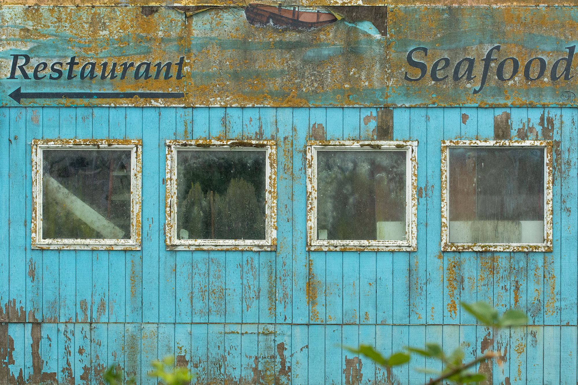 A photo from Garibaldi, Oregon shows old windows and bright turquoise paint for a story about AirBNB nightmares.