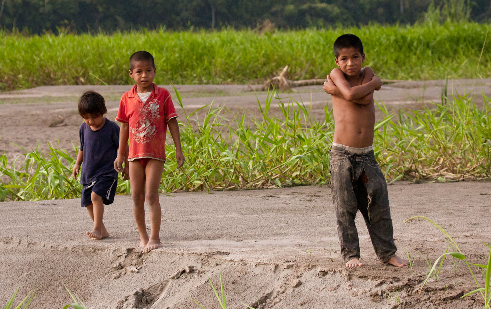 Boys play on a tropical river island in the Napo River, where their dad left them for the day