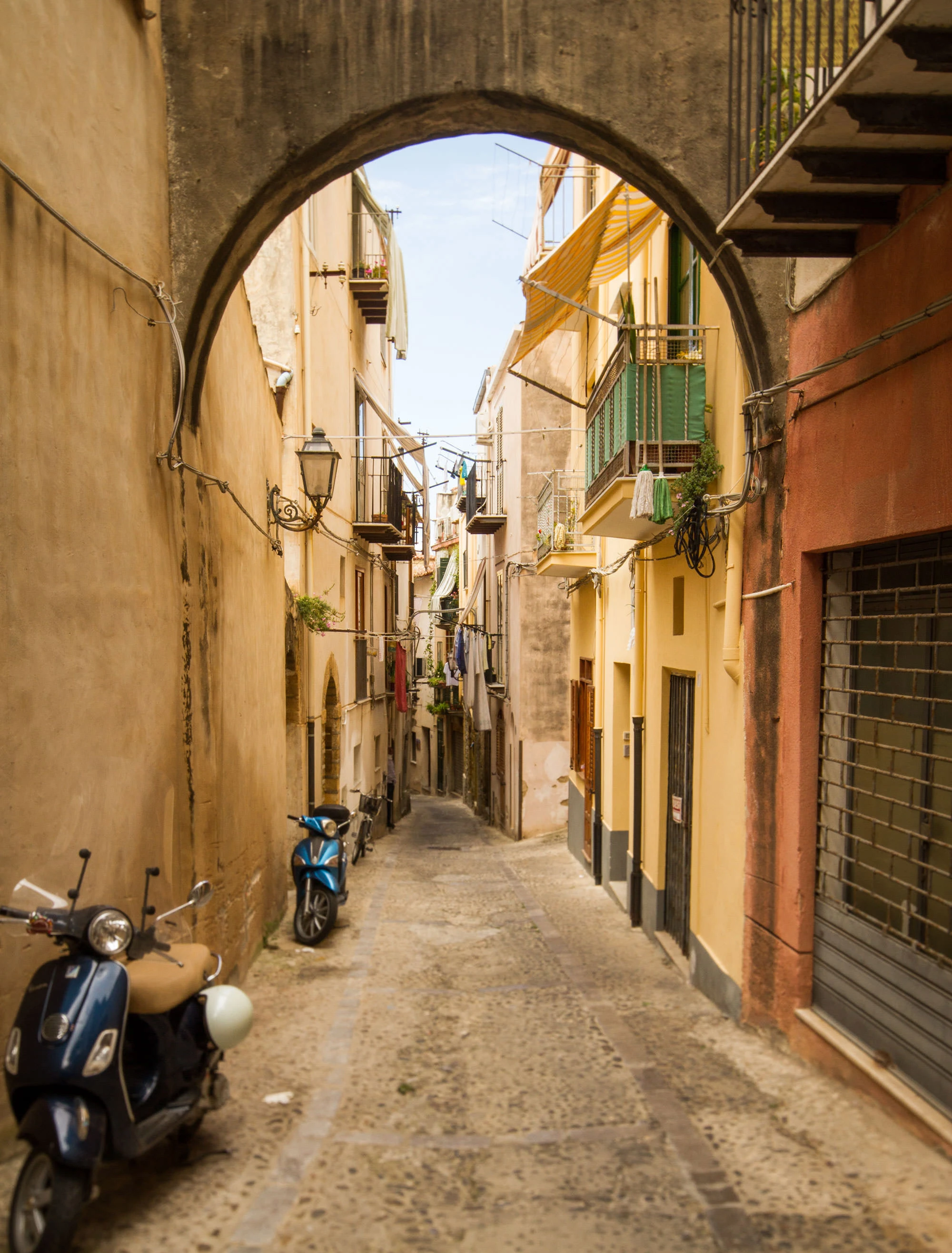 Alley with mopeds in Cefalù, Sicily.