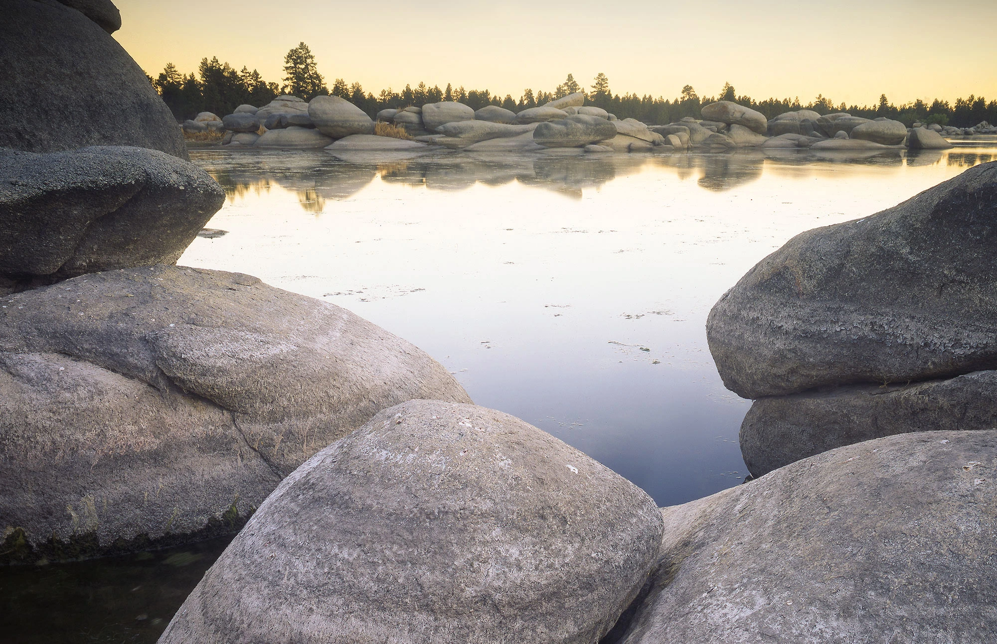Laguna Hanson (Hansen Lake), a serene alpine lake tucked at about 1,580 m elevation in Mexico's Constitution 1857 National Park, surrounded by granite boulders and towering pines in the Sierra de Juárez, a seasonal wetland and Ramsar-designated site that supports migratory ducks and rich high-elevation biodiversity.