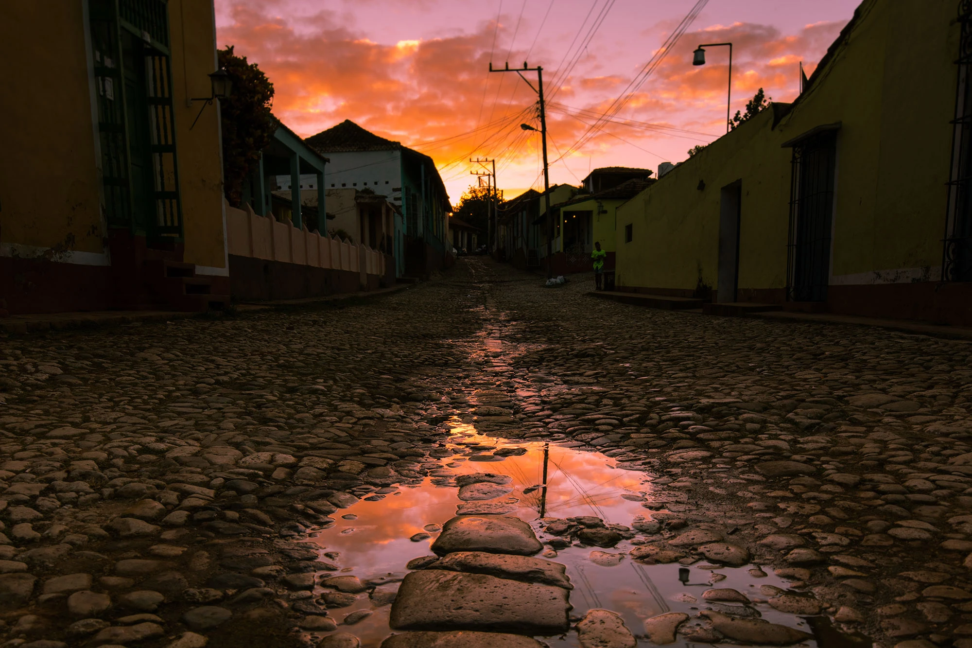 Early morning street scene in Trinidad, Cuba, where pastel houses line the cobblestone street and soft sunlight falls across doorways as the town begins to wake.